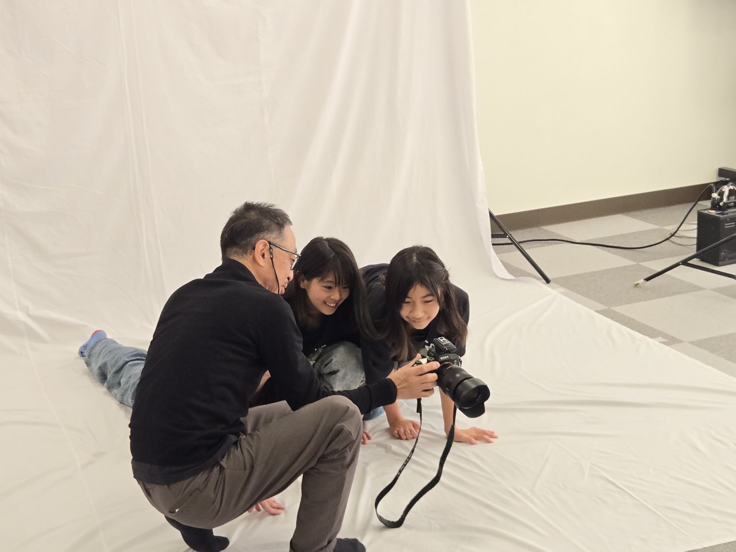うつ伏せになってお子さんの目線に合わせるカメラマン